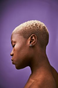 Close-up of shirtless woman against colored background