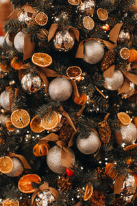 Creative christmas tree decorated with dry oranges, pine cones and golden christmas balls. magic