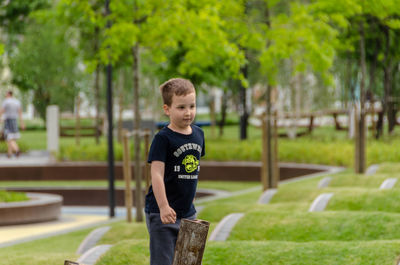 Full length of boy on grass against trees