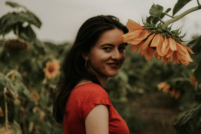 Portrait of young woman standing at sunflower farm