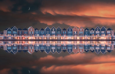 Reflection of buildings in city at sunset