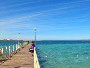 Pier over sea against blue sky