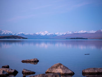 Scenic view of lake and mountains against blue sky