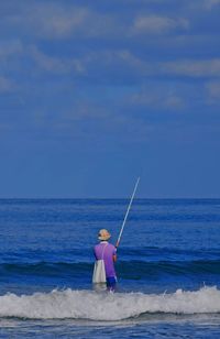 Rear view of man fishing on beach