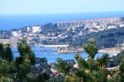Scenic view of sea and cityscape against clear sky