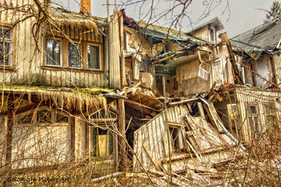 Abandoned house against buildings