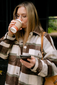 Midsection of woman holding coffee cup