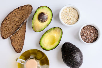 Ingredients for healthy avocado toast. ripe hass avocado, wholegrain bread, sesame flax seeds. vegan