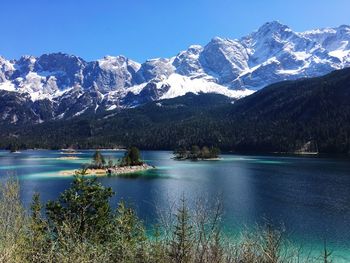 Scenic view of lake and snowcapped mountains against sky