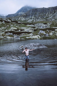 Rear view of a boy standing in lake