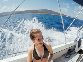 High angle view of smiling woman sitting in yacht