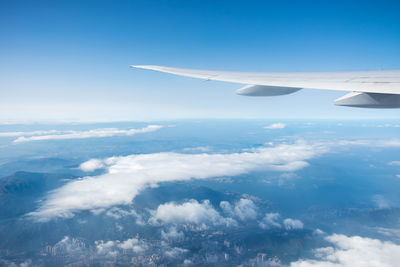 Aerial view of aircraft wing over clouds