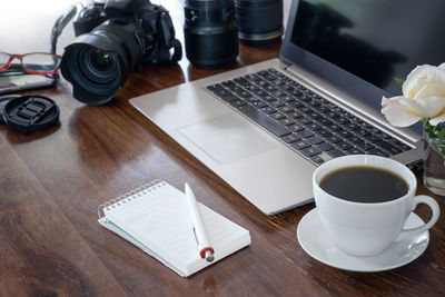 High angle view of coffee and laptop on table