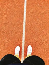 Low section of man standing on running track