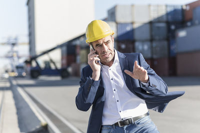 Portrait of businessman on the phone at industrial site