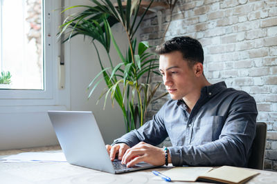 Young man using laptop at office