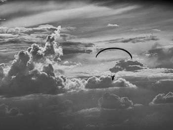 Low angle view of paragliding flying against sky