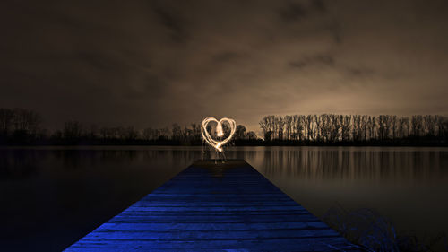 Heart shape light painting at lakeshore during night