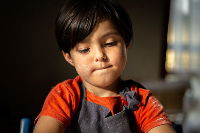 Portrait of girl with dark short hair with face dirty of flour