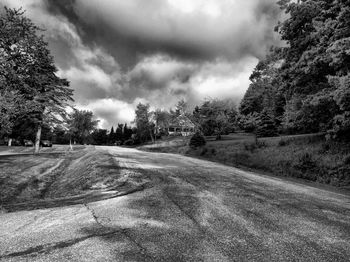 Empty road against cloudy sky