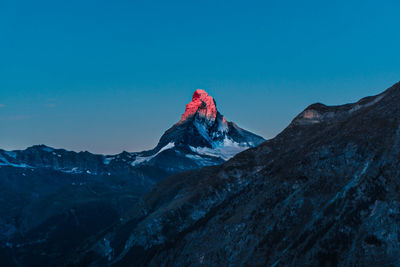 Scenic view of snowcapped mountains against clear blue sky