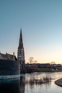 Church by building against clear sky