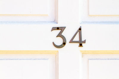 House number 34 on a white wooden front door in london 