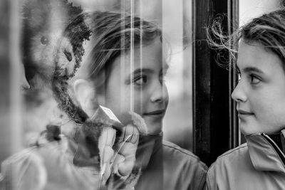 Close-up of girl reflecting on glass window