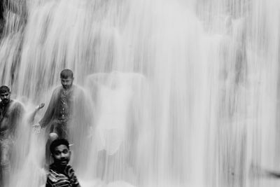 Male friends enjoying waterfall