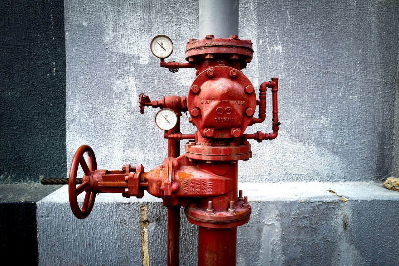 CLOSE-UP OF FIRE HYDRANT BY WALL