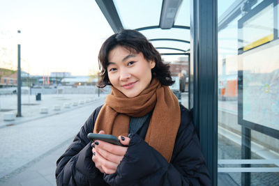 Portrait of young woman using phone