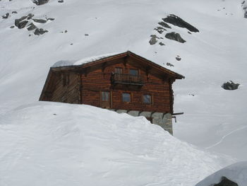 Snow covered house and buildings against mountain