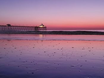 Pier over sea against sky during sunset