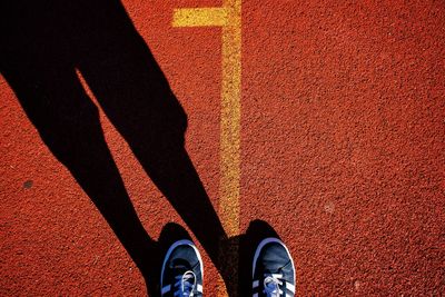 Low section of person wearing shoes on running track