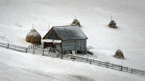 House on snow covered field by houses