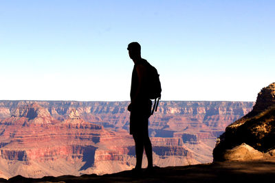 Rear view of man standing on rock