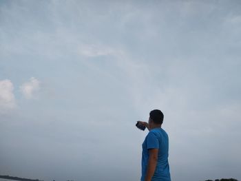 Rear view of man standing against sky