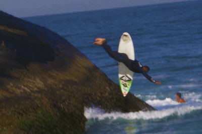 Rear view of woman jumping on beach