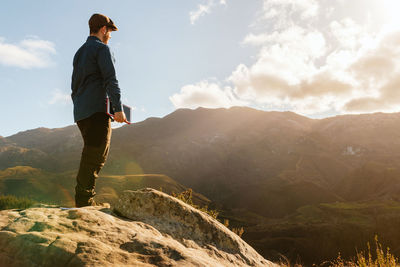 Man looking at mountains against sky
