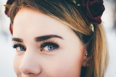 Close-up portrait of woman wearing rose on hair