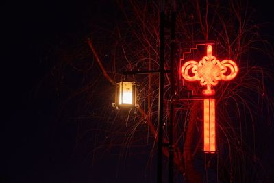 Close-up of illuminated light against sky at night