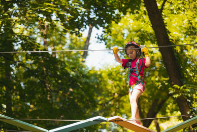 Low angle view of young woman standing on rope