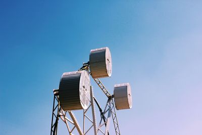 Low angle view of crane against clear blue sky