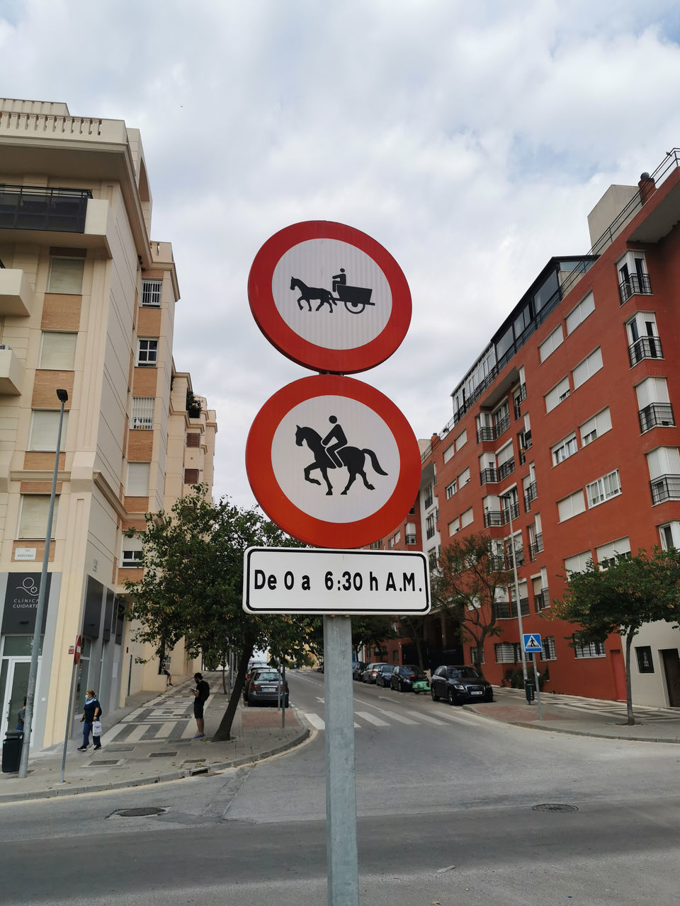 ROAD SIGN ON CITY STREET AGAINST BUILDINGS