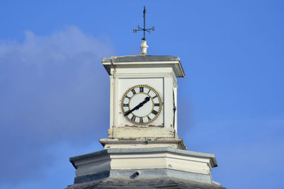 Low angle view of clock tower against blue sky