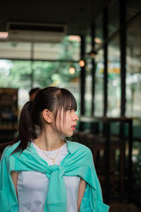 Woman looking away while sitting on floor