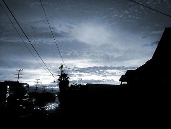 Power lines against cloudy sky