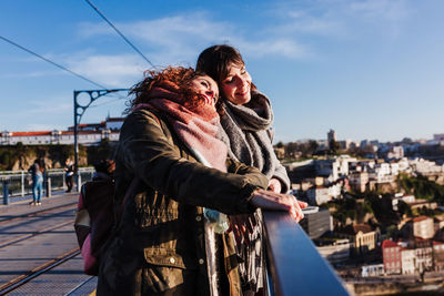 Two happy friends porto bridge sightseeing at sunset. travel, friendship and lifestyle