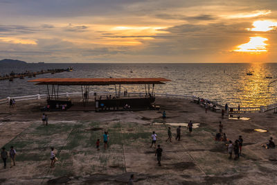 Silhouette of people on beach at sunset