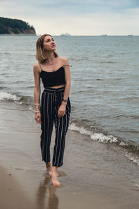 Young woman standing on blurred beachside background. attractive female enjoying walking the sea